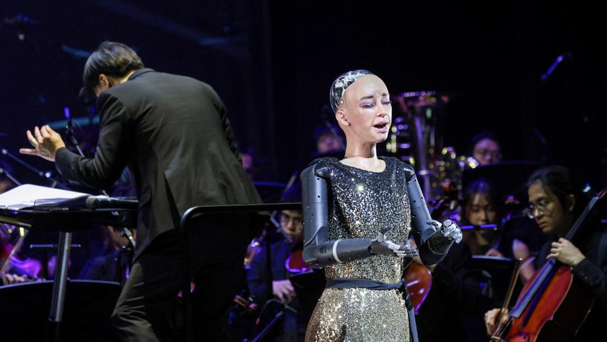 Robot humanoid Sophia mencatatkan debut unik di panggung musik klasik dengan tampil bersama orkestra langsung di Hong Kong, Rabu (29/4/2026), dalam konser bertema kecerdasan buatan (AI) yang memadukan seni tradisional dan inovasi teknologi. (REUTERS/Tyrone Siu)