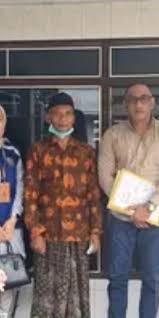 Petugas dari Dinas Perindustrian dan Tenaga Kerja Bangkalan foto bersama keluarga Pekerja Migran Indonesia yang meninggal dunia di Taiwan. ANTARA/ HO-Pemkab Bangkalan