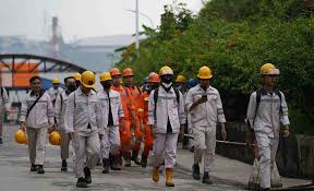 Ribuan karyawan di kawasan IMIP mengenakan seragam alat pelindung diri lengkap berjalan sepulang jam kerja. Mobilitas para pekerja menjadi pemandangan harian dari ritme industri yang terus bergulir.