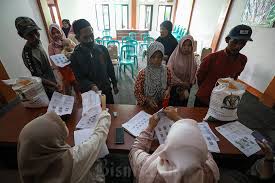 Petugas melakukan verifikasi data penerima bansos saat penyaluran bantuan pangan beras di Desa Sukaharja, Ciomas, Kabupaten Bogor, Jawa Barat. Bisnis/Arief Hermawan P
