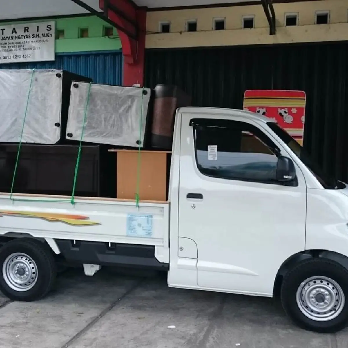 close-up bak belakang mobil pick up bermuatan penuh barang logistik dijalan raya (Foto: 2)