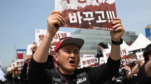 Members of the Samsung Electronics labour union hold signs reading 