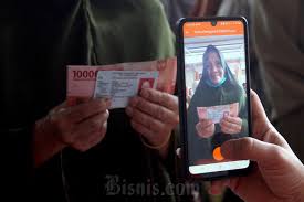 Warga mengantri mengambil Bantuan Sosial dari pemerintah dikantor PT Pos di Makassar, Sulawesi Selatan, Jumat (25/11). Bisnis/Paulus Tandi Bone