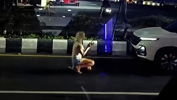 Foto: Seorang perempuan warga negara asing terlihat berlutut di depan mobil di Jalan Tugu Ngurah Rai, Nusa Dua, Badung, Kamis (21/5/2026) malam. (dok. tangkapan layar akun instagram @denpasarviralcom)