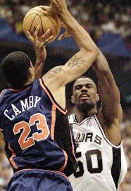 David Robinson (R) of the San Antonio Spurs shoots over Marcus Camby of the New York Knicks 18 June 1999 during game two of the NBA Finals at the Alamodome in San Antonio, TX. (JEFF HAYNES, AFP via Getty Images)
