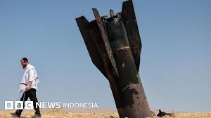 Keterangan gambar, Sebagian rudal terlihat menonjol dari tanah di Tepi Barat yang diduduki Israel, menyusul serangan dari Iran.