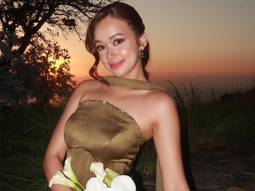 Rebecca Klopper mengenakan gaun bernuansa olive gold dengan model strapless ditambah potongan korset melekat sempurna di tubuhnya. Detail payet halus di bagian dada dan pinggang memberikan sentuhan mewah yang pas tanpa terkesan berlebihan. Riasan wajahnya yang glowing berpadu apik dengan anting geometris bernuansa emas. (Foto: dok Instagram rklopperr)