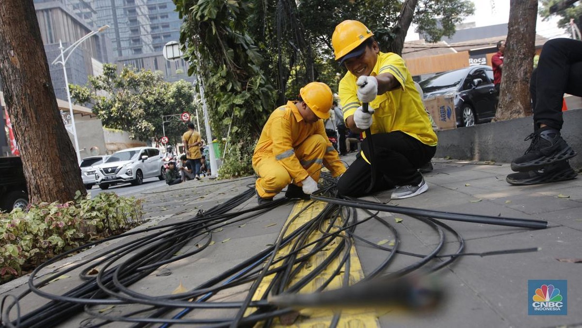 Foto: Petugas dari DInas Bina Marga DKI Jakarta melakukan pemotongan kabel semrawut di Sepanjang jalan Senopati, Kebayoran Baru, Jakarta Selatan, Kamis (24/8/2023). (CNBC Indonesia/Muhammad Sabki)