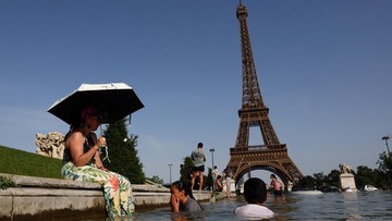Warga berendam di Trocadeno di depan Menara Eiffel saat gelombang paanas menerpa. (Abdul Saboor/Reuters)