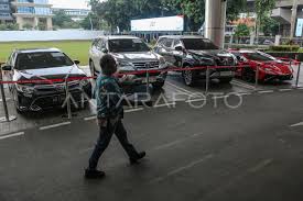 Pekerja melintas di depan sejumlah mobil sitaan penyidik Jaksa Agung Muda Bidang Tindak Pidana Khusus (Jampidsus) di Kejaksaan Agung, Jakarta, Jumat (3/7/2026). Kejaksaan Agung menyita sejumlah aset berupa mobil Lamborghini, Toyota Fortuner, Toyota Camry, ekskavator, dump truck, dan kapling tanah milik beneficial owner (pemilik manfaat) PT QSS berinisial SDT alias Aseng yang merupakan tersangka kasus dugaan korupsi penyimpangan tata kelola izin usaha pertambangan (IUP) di Kalimantan Barat tahun 2017-2025. ANTARA FOTO/Asprilla Dwi Adha/wsj.