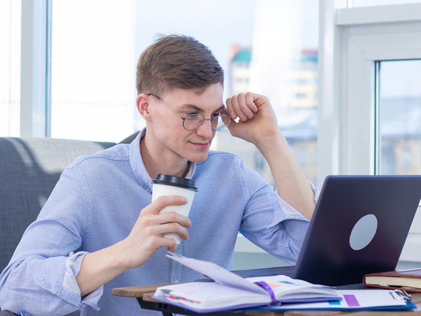Seseorang sedang bekerja dengan laptop sambil mencatat ide kreatif di tengah suasana kafe yang modern.